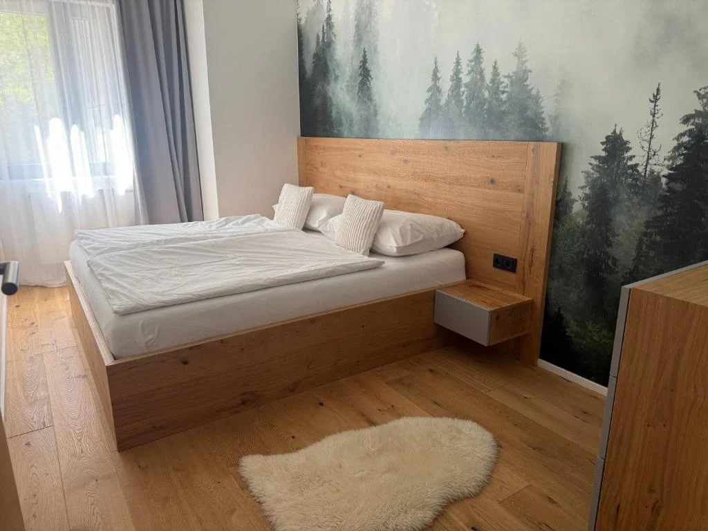 Samostatná ložnice s manželskou postelí a lesním motivem